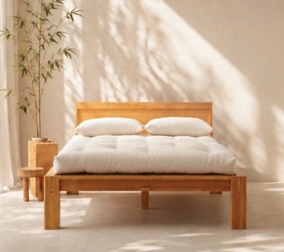 Real-wood bed frame with a futon mattress in a sunlit bedroom